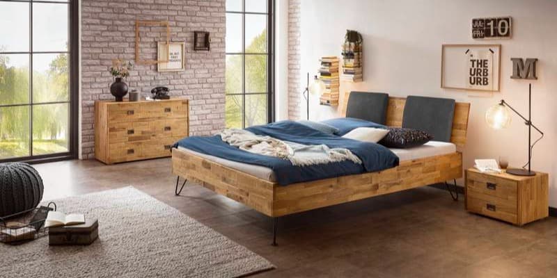 Schlafzimmer mit Holzmöbeln und blauer Bettwäsche